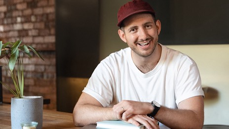 Man sits at table with notepads 